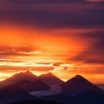 the sun is setting over a mountain range